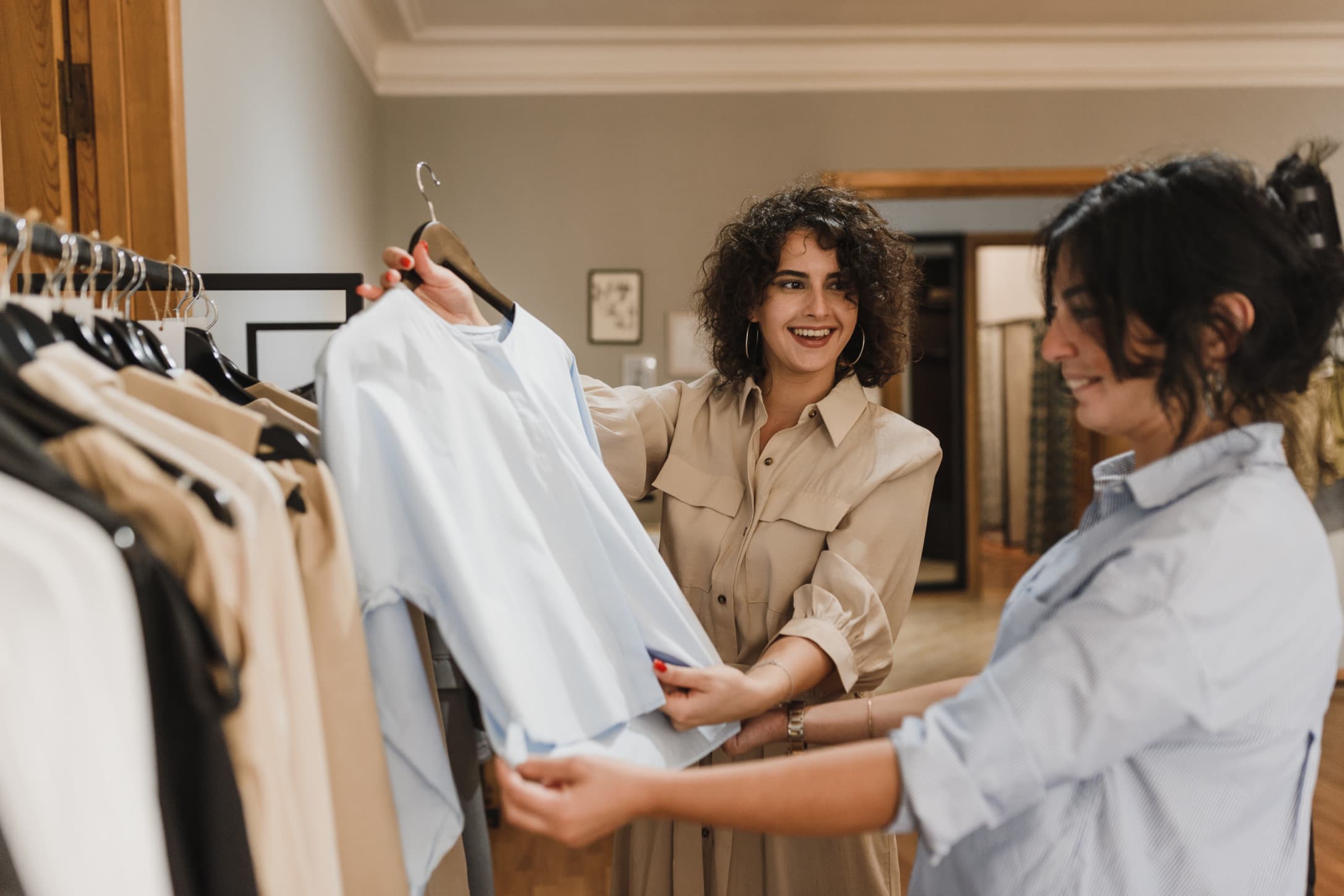 Two friends shopping for clothes, happy and smiling